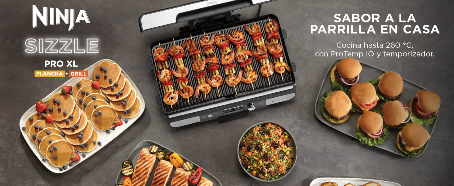 El texto dice «NINJA SIZZLE PRO XL» y «SABOR A LA PARRILLA EN CASA». En la superficie de la parrilla eléctrica se muestran varios alimentos, como carnes en brochetas, hamburguesas y una guarnición.