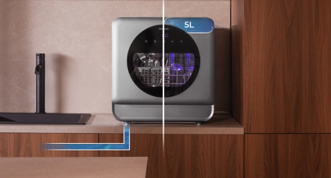 Dispositivo digital moderno en forma de cubo con pantalla circular, que se muestra en un entorno doméstico con un fondo de muebles de madera.