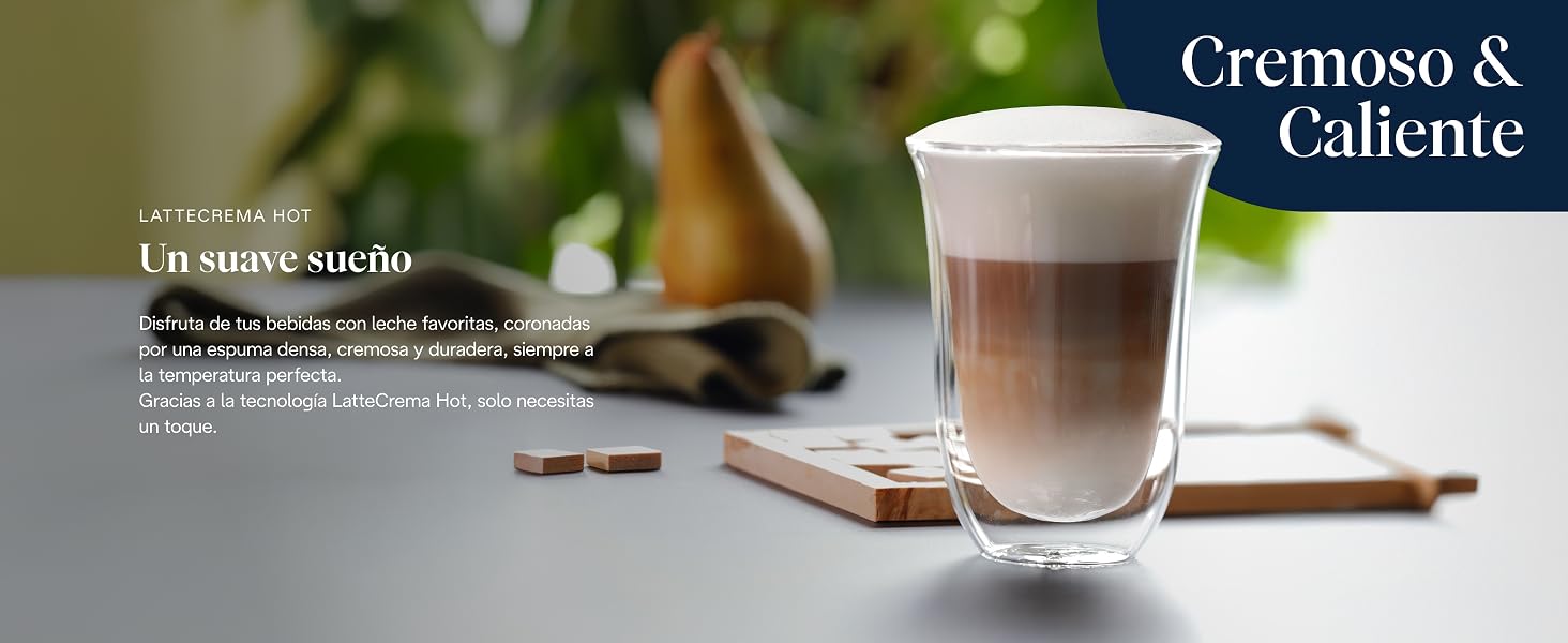 El texto dice «Cremoso &amp; Caliente». Fotografía de productos de café o bebida en vidrio transparente con una capa superior cremosa sobre un fondo borroso.